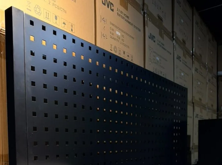 Black steel pegboard backboard behind a showroom counter