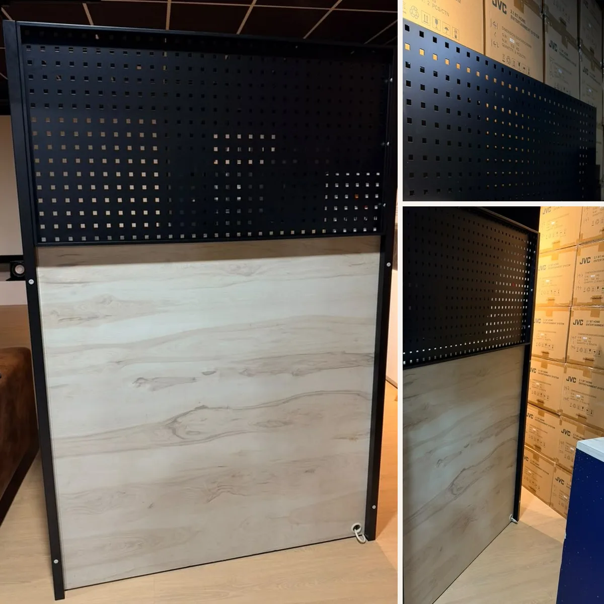 Black steel pegboard on support poles used as a free-standing partition and counter backboard in a Malaysian showroom