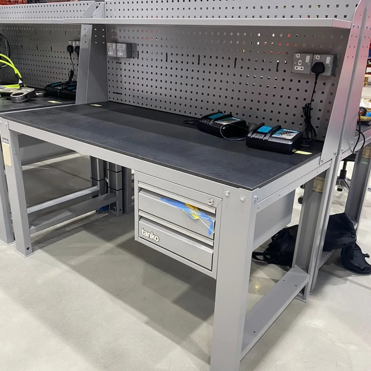 Row of Tanko workbenches with pegboard uprights, power sockets and lockable drawers